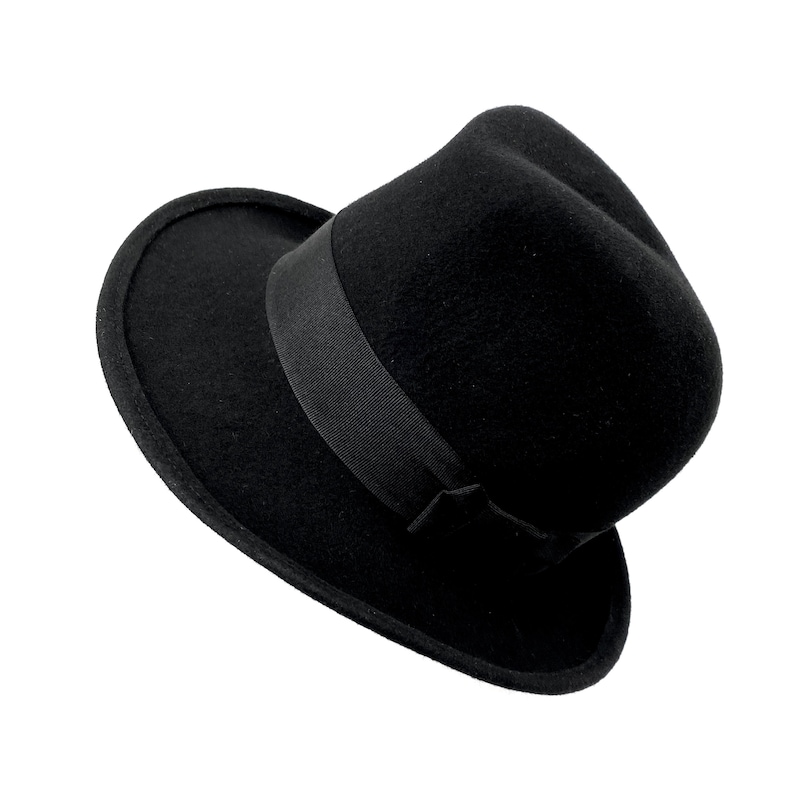 Op de afbeelding: Een zwarte fedora hoed met een brede rand en een zwart lint.