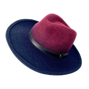 May include: A burgundy felt fedora hat with a black leather band and a black felt brim.