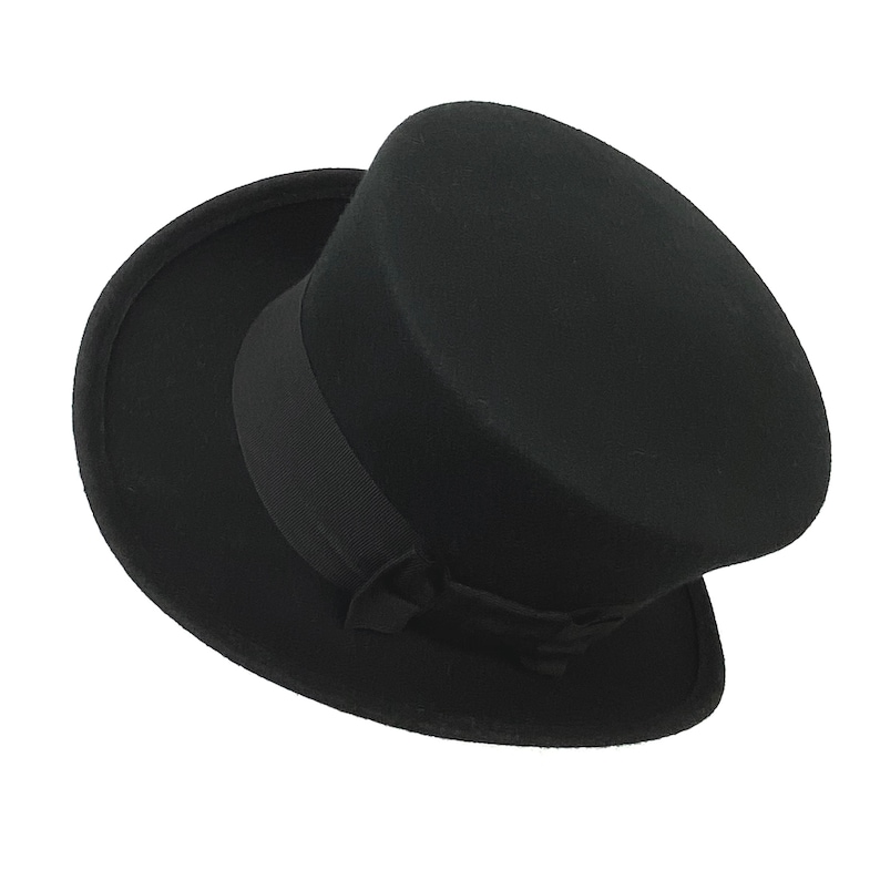 May include: A black felt top hat with a wide brim and a black ribbon.