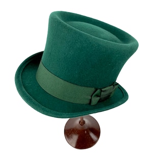 May include: A dark green top hat with a wide brim and a green ribbon around the crown.