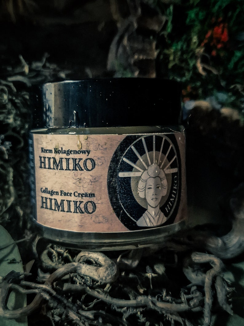 以下が含まれることがあります： 黒い蓋と「Krem Kolagenowy HIMIKO Collagen Face Cream HIMIKO」と書かれたラベルが付いた、小さな丸い顔用クリームの瓶。ラベルには、伝統的な日本の着物姿の女性の絵も描かれている。