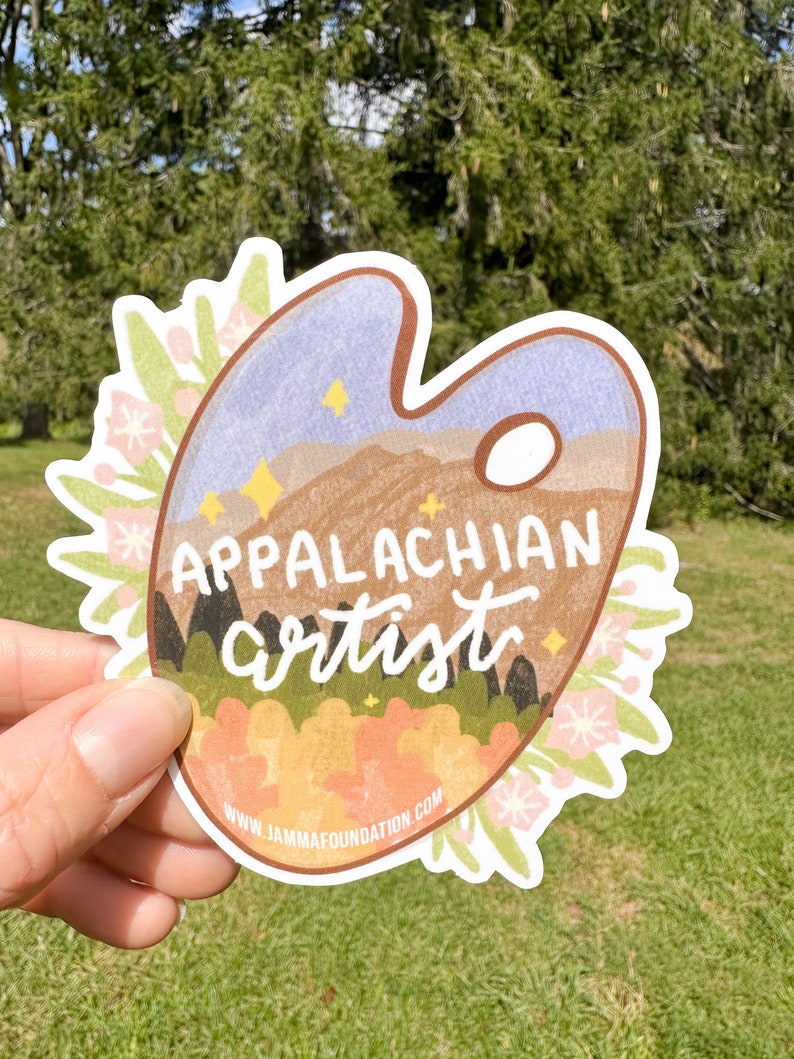 May include: A sticker featuring a paint palette with a mountain scene and the text "Appalachian artist" in a brown, white, and green color scheme. The sticker is surrounded by a floral border and includes the website "www.jammfoundation.com".