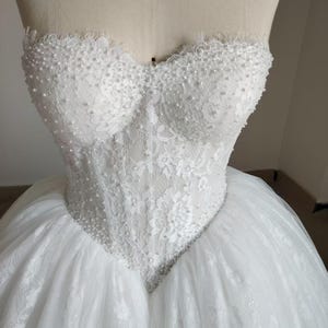 Vestido de novia de gala sin tirantes con perlas y pedrería hecha a mano, escote corazón, corsé de encaje y tul. imagen 9