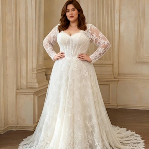 May include: A floor-length white wedding dress featuring long sheer lace sleeves, a sweetheart neckline, and a structured corset-style bodice. The gown is adorned with intricate floral lace appliques that extend from the bodice down to the hem.