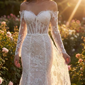 May include: An off-the-shoulder white lace wedding dress featuring long sleeves, a corset-style bodice with visible boning, and a floor-length skirt with intricate floral embroidery and scalloped lace edges along the neckline and sleeve cuffs.