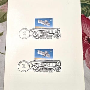 May include: Two off-white envelopes featuring 37-cent USA postage stamps depicting the Wright brothers' aircraft. Each envelope includes a black ink postmark dated May 22, 2003, from Dayton, OH and Kill Devil Hills, NC, with the text First Flight.