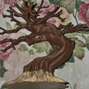 May include: A brown, three-dimensional printed sculpture of a leafless tree with a gnarled, textured trunk and spreading branches. The base of the tree transitions into a lighter tan color, featuring a flat, wide bottom for stability on surfaces.