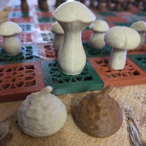 May include: A unique mushroom-themed chess set. The chess pieces are shaped like mushrooms in shades of white and brown. The board is green, red, and brown with a decorative pattern. A creative and whimsical board game.