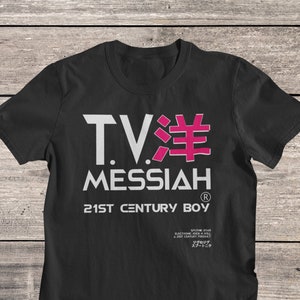 May include: Black t-shirt with a white graphic design that says "TV洋 MESSIAH" with a pink "洋" character. The text "21ST CENTURY BOY" is below the graphic, and the text "SPUTHK 2049 ELECTRONIC ROCK N ROLL A 21ST CENTURY PRODUCT" is below that. The text "ジグのジグ スプートニク" is below that.