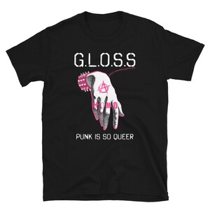 May include: Black t-shirt with white text that reads "GLOSS" and "PUNK IS SO QUEER". A pink hand with an anarchy symbol and the word "HOMO" is printed on the shirt.