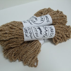 May include: Two skeins of brown organic cotton yarn, each labeled "100 Yards Alabama Organic Cotton Handspun Yarn".