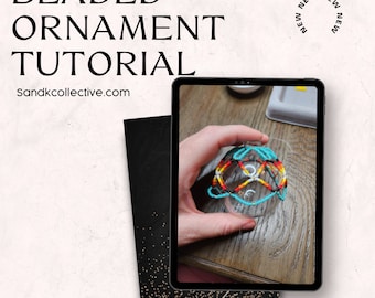 May include: A tablet displays a beaded ornament tutorial. The ornament is clear with a colorful beaded design in red, yellow, and turquoise. The text "BEADED ORNAMENT TUTORIAL" and "Sandkcollective.com" are visible.
