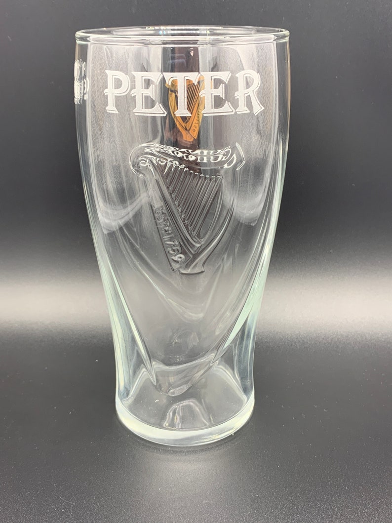 May include: A clear glass pint glass with the name "PETER" etched on the front. The glass features a raised, etched harp design with the text "ESTD 1778" below it.