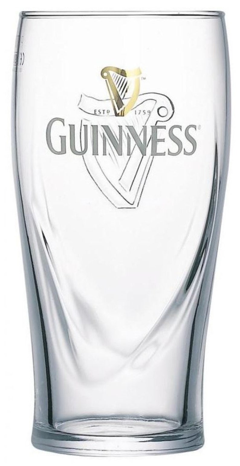 May include: A clear glass pint glass with a Guinness logo. The logo features a gold harp and the text "ESTD 1759 GUINNESS".