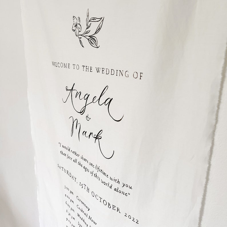 May include: A wedding announcement with a simple floral design. The text reads "Welcome to the wedding of Angela & Mark" and includes the date "Saturday, 15th October 2022" and a list of wedding events.