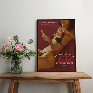 May include: A vintage-style poster featuring a woman in a bikini drinking a Coca-Cola. The poster has a red background with white text that reads "Please don't do Coke in the bathroom".