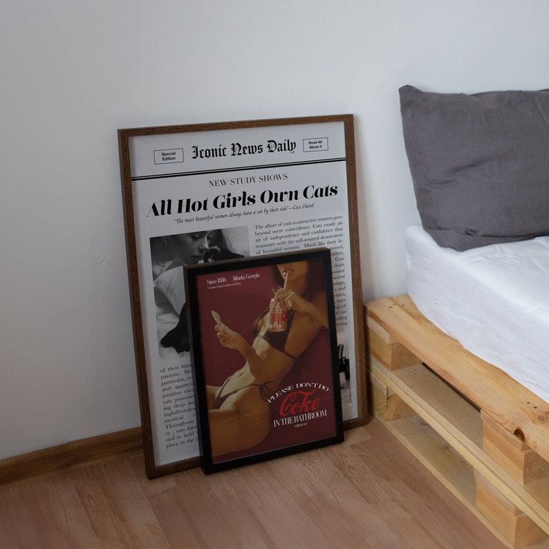 May include: A framed newspaper article with the headline "All Hot Girls Own Cats" and a framed vintage advertisement for Coca-Cola with the text "Please don't do Coke in the bathroom".