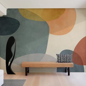 Può includere: Scena d'interni con un grande murale con forme astratte nei toni tenui del verde acqua, arancione e beige. Un divanetto in tessuto con gambe scure e un cuscino a fantasia bianco e nero è di fronte al murale. Una scultura nera si trova a sinistra.