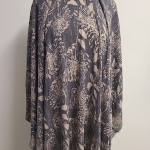 May include: A dark gray fabric with a light brown floral print. The fabric has a textured surface and a subtle sheen.