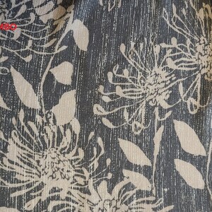 May include: Dark olive fabric with a beige floral print. The fabric has a textured, woven look.