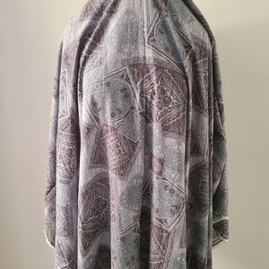 May include: A gray and brown fabric with a repeating pattern of geometric shapes. The fabric has a soft, textured feel.