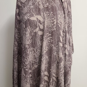 May include: A brown fabric with a white floral print. The fabric has a textured surface and a subtle sheen.