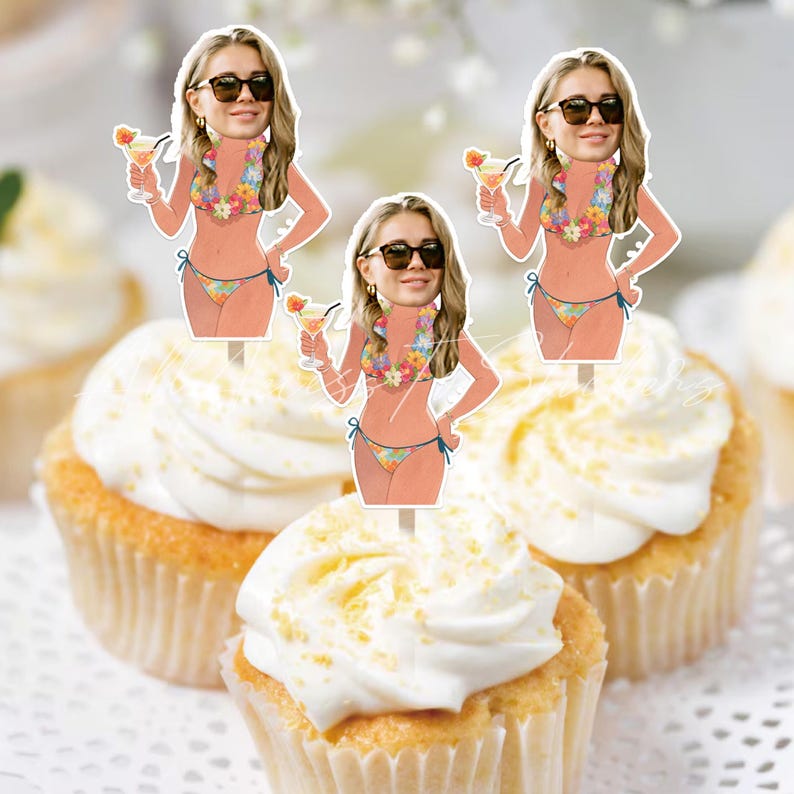 May include: Three cupcake toppers featuring a cutout illustration of a person with blonde hair wearing dark sunglasses and a floral bikini, holding a tropical cocktail with a small umbrella. The figures are mounted on thin sticks for decoration.