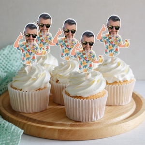 May include: A set of four cupcake toppers featuring a cartoon illustration of a person with a beard, wearing black sunglasses and a floral print shirt, giving a thumbs up while holding a yellow drink with a straw, attached to wooden sticks.