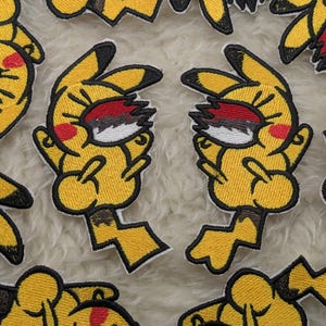 May include: Embroidered yellow patches of a cartoon character with black-tipped ears, red cheeks, and a lightning bolt tail. The character's eyes are closed, with red, white, and black details. These patches are suitable for clothing or accessories.