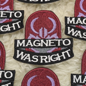 Op de afbeelding: Vijf geborduurde patches met een paars en rood ontwerp en de tekst "Magneto Was Right" in witte en zwarte letters.