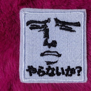 Peut inclure: Un patch blanc avec un visage brodé en noir et le texte "Pâstille?" en noir.