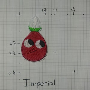 May include: Red embroidered patch of a cartoon character with large eyes, a red body, green leaves, and a white flower on top. The character has a small mouth and a red nose. The patch is labeled "Imperial".