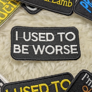 Könnte beinhalten: Schwarzer gestickter Aufnäher mit weißem Text, der "I USED TO BE WORSE" lautet.