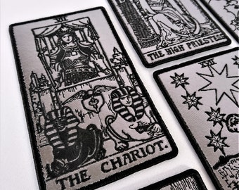 May include: Set of seven silver and black embroidered iron-on patches featuring tarot card imagery. The cards include The High Priestess, The Chariot, The Star, and The Emperor.