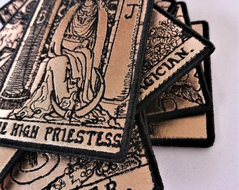May include: A stack of tarot cards with black borders and gold backgrounds. The top card shows the High Priestess, the next card shows the Magician, and the bottom card shows The Star.