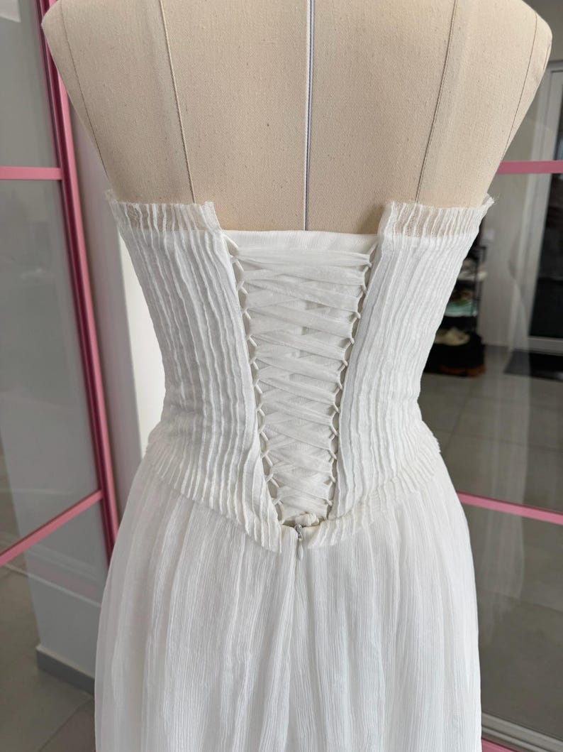 a white dress on a mannequin in a room