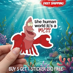 Pode incluir: Um adesivo recortado apresentando um caranguejo vermelho de desenho animado com rosto e barriga rosa claro. O texto diz, the human world it's a MESS. O caranguejo tem pin&ccedil;as grandes e est&aacute; posicionado contra um fundo subaqu&aacute;tico com corais e bolhas.