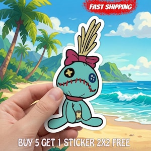 May include: A teal voodoo doll sticker featuring a pink bow, yellow and blue button eyes, and red stitched mouth details. The doll has a tuft of tan hair on top and a small yellow patch on its torso, presented as a die-cut vinyl sticker design.