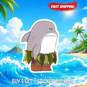 May include: A die-cut sticker featuring a cartoon shark with a gray body and white underbelly, wearing a green leaf skirt and brown patterned leg wraps. The background shows a tropical beach with blue ocean waves, palm trees, and a bright sun.