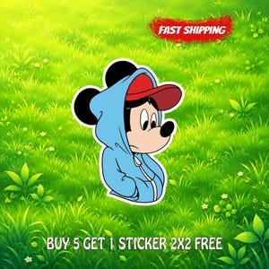 May include: A sticker featuring a cartoon mouse character wearing a light blue hooded sweatshirt and a red baseball cap. The character has black ears, a tan face, and a black nose. The sticker is set against a bright green grassy background.