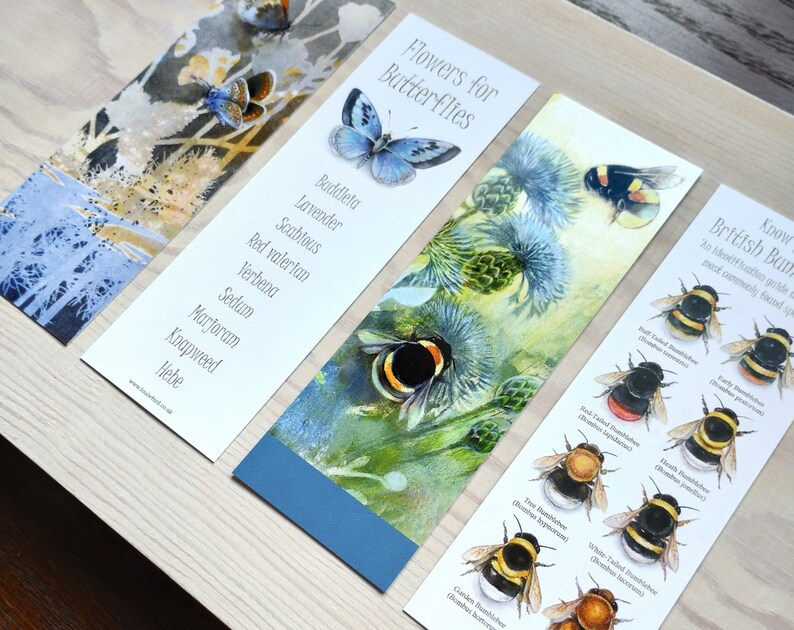 May include: Three bookmarks with watercolor illustrations of flowers and bees. The first bookmark lists flowers that attract butterflies, the second bookmark shows a bee on a thistle flower, and the third bookmark shows a guide to identifying British bumblebees.
