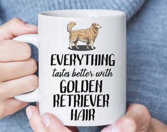 May include: White ceramic coffee mug with a black illustration of a golden retriever and the text "EVERYTHING tastes better with GOLDEN RETRIEVER HAIR".