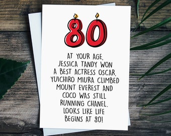 May include: A birthday card with a red number 80 with flames on top. The card reads "At your age, Jessica Tandy won a best actress Oscar, Yuichiro Miura climbed Mount Everest and Coco was still running Chanel. Looks like life begins at 80!"