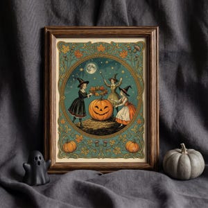 May include: A framed art print featuring three figures in pointed hats surrounding a large jack-o'-lantern under a full moon. The illustration is enclosed in a circular border with decorative autumn leaves, thistles, and two smaller pumpkins.