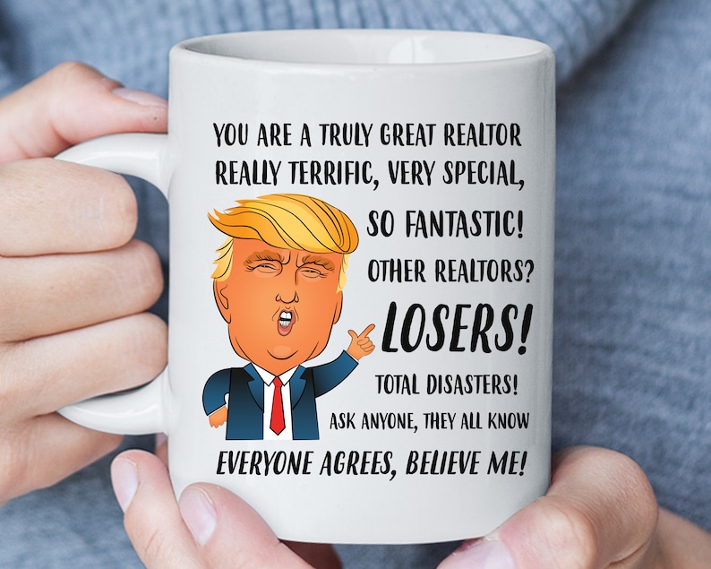 May include: White ceramic coffee mug with a cartoon image of Donald Trump and the text "You are a truly great realtor really terrific, very special, so fantastic! Other realtors? Losers! Total disasters! Ask anyone, they all know everyone agrees, believe me!"