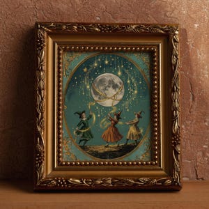 May include: A rectangular gold-toned ornate frame containing an illustration of three figures in pointed hats dancing beneath a large moon and falling stars. The figures hold golden ribbons connected to the moon against a teal background.