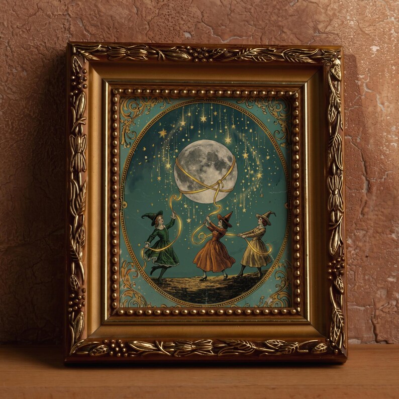May include: A rectangular gold-toned ornate frame containing an illustration of three figures in pointed hats dancing beneath a large moon and falling stars. The figures hold golden ribbons connected to the moon against a teal background.