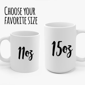 May include: Two white ceramic mugs with black lettering. The mug on the left says "11oz" and the mug on the right says "15oz".