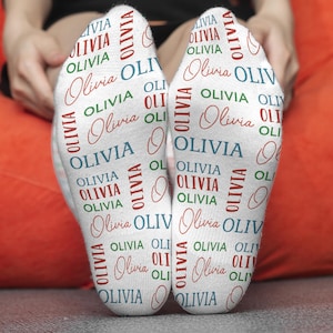 May include: White socks with the name Olivia repeated in red, blue, and green lettering.