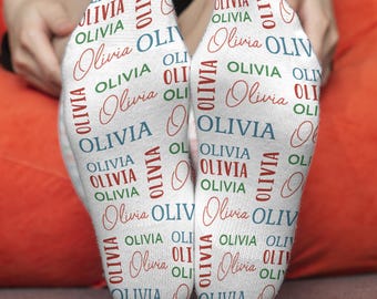 May include: White socks with the name Olivia repeated in red, blue, and green lettering.